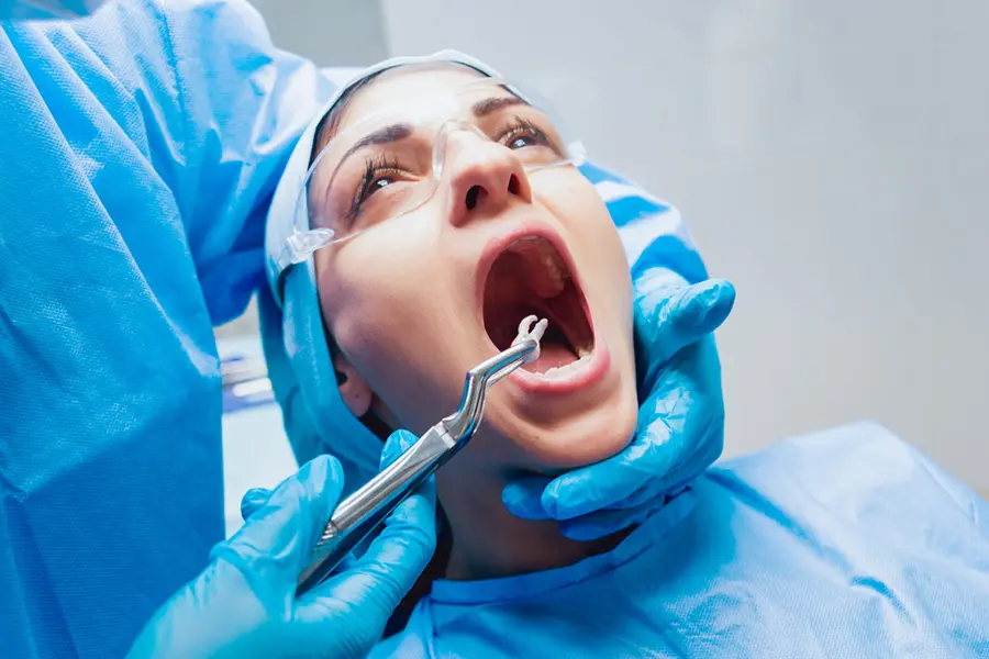 dentist-using-surgical-pliers-remove-decaying-tooth-modern-dental-clinic